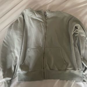 Brandy Melville, small light green zip up. small pen stain on back.